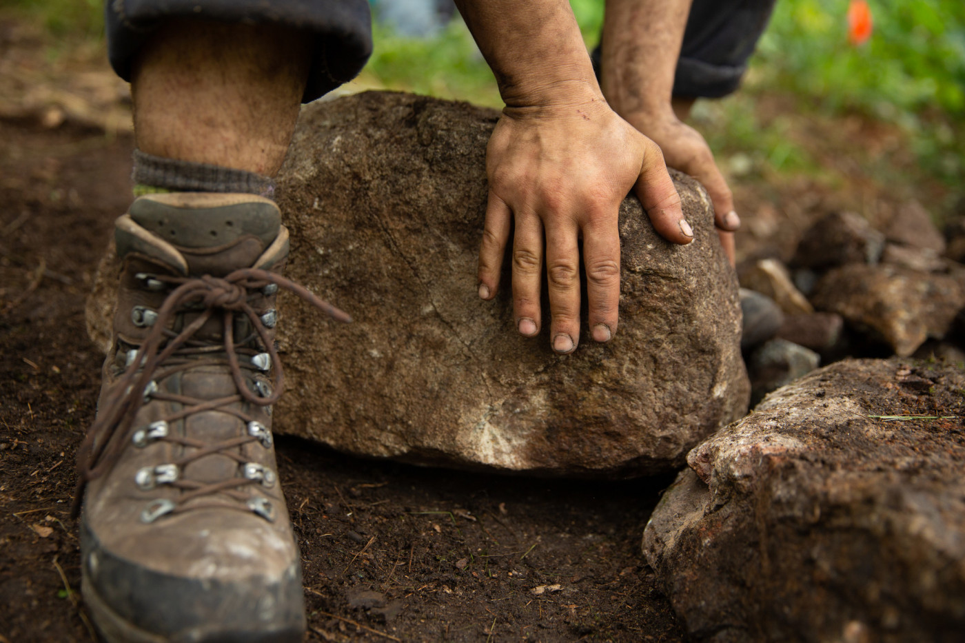 Those rocks aren't going to move themselves — Nips sets a stone in a walkway the old fashioned way.