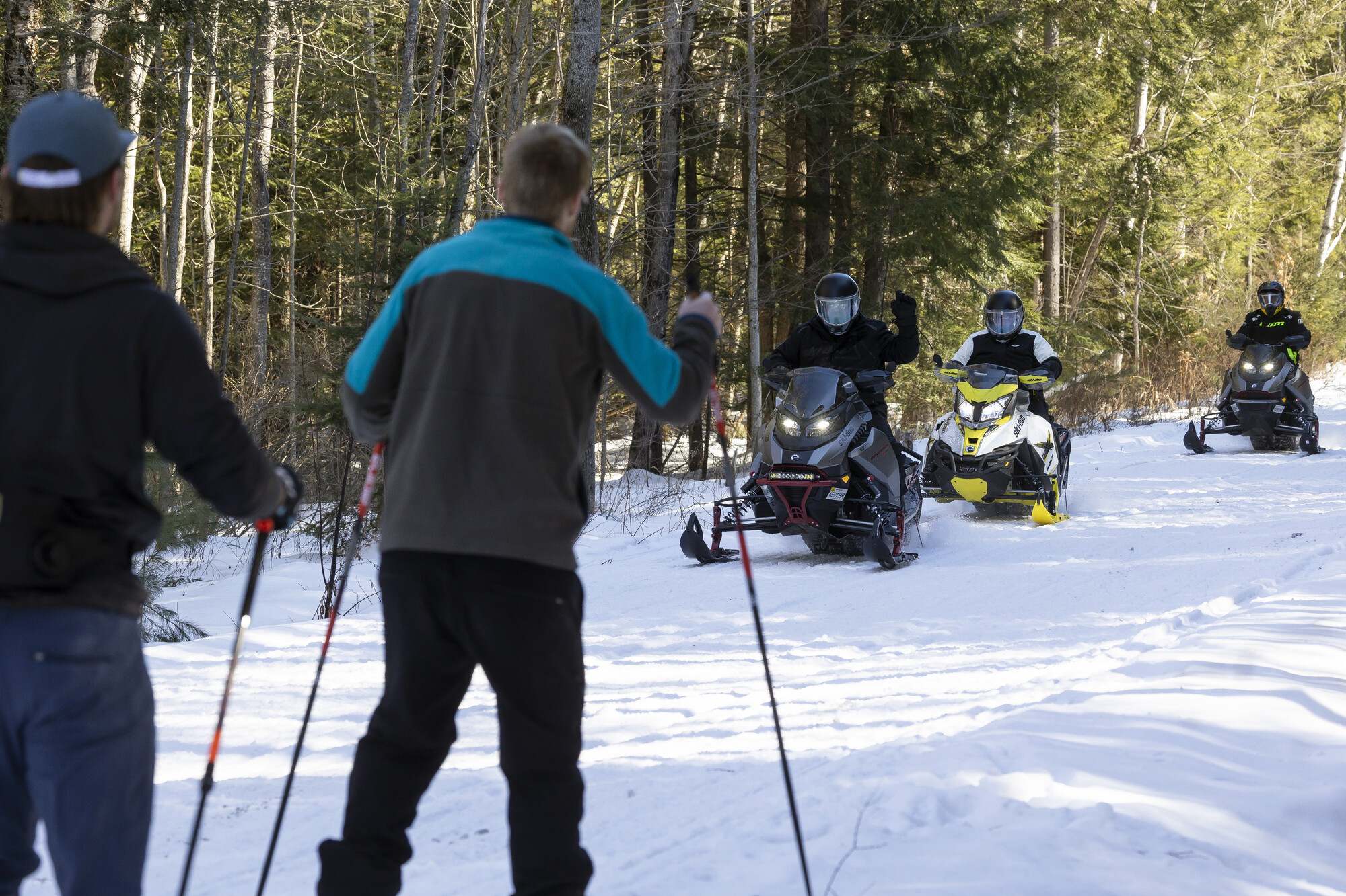 Skiers and snowmobilers on the Rail Trail