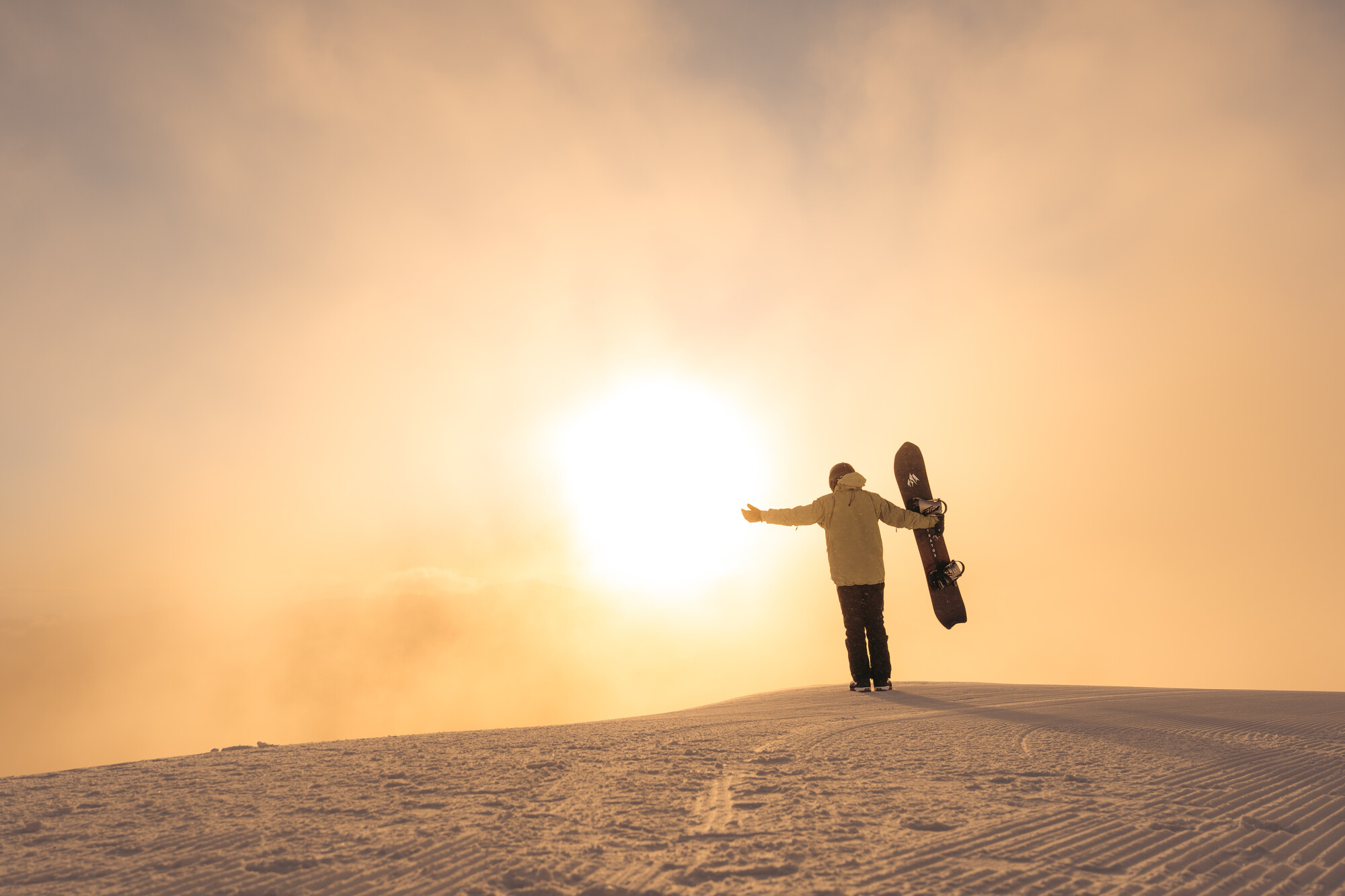 A snowboarder basking in the morning sun
