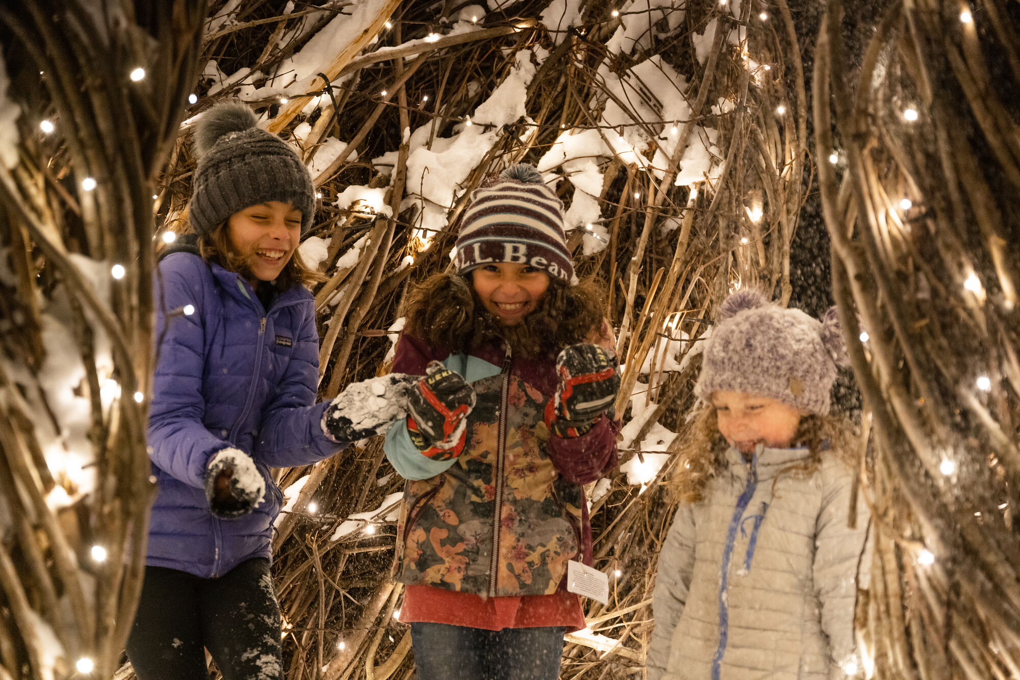 Three kids in a lit up winter art installation