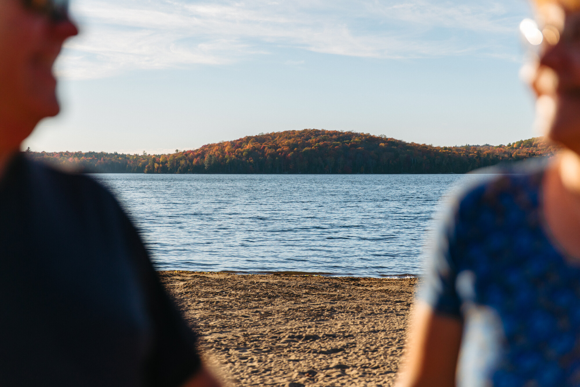 An older couple on a beach during the fall