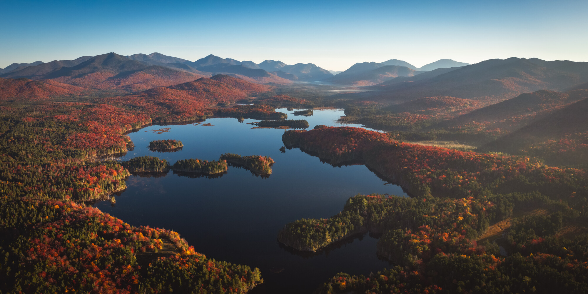 Aerial view of a massive pond in the high mountains during fall