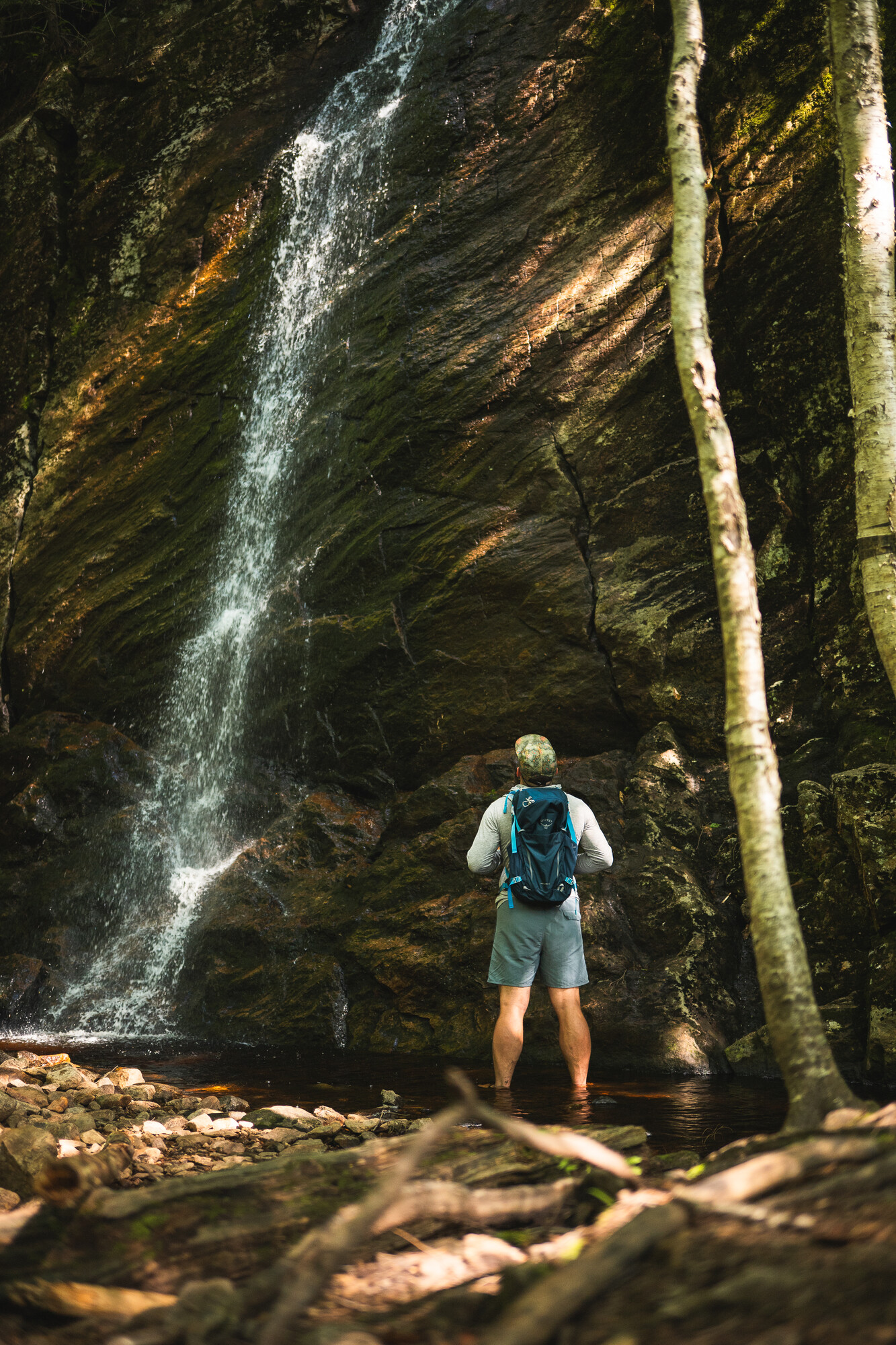 A solo hiker next to a waterfall