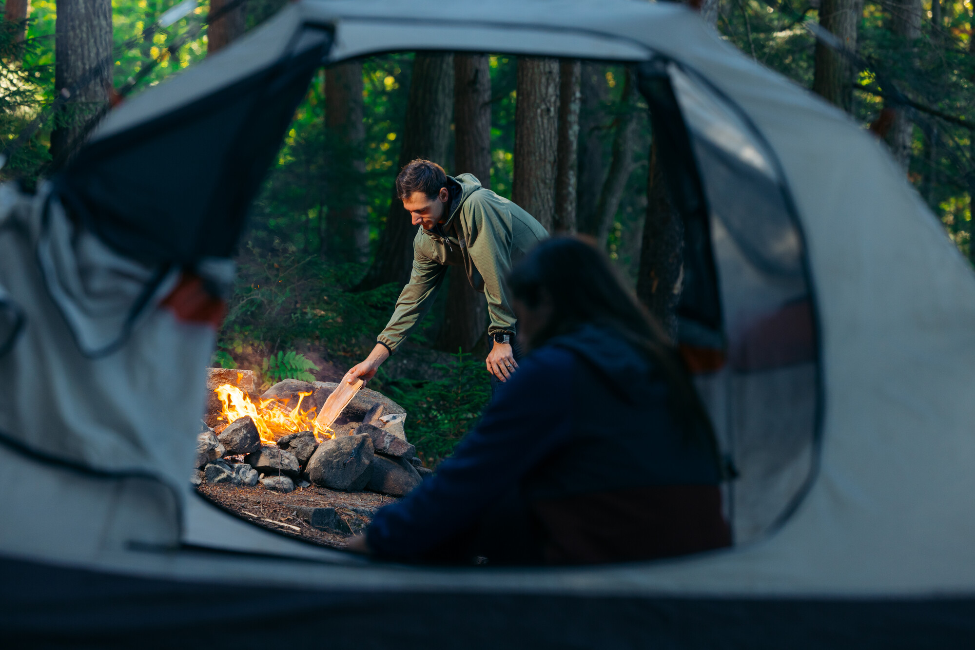 Two people camping by a fire