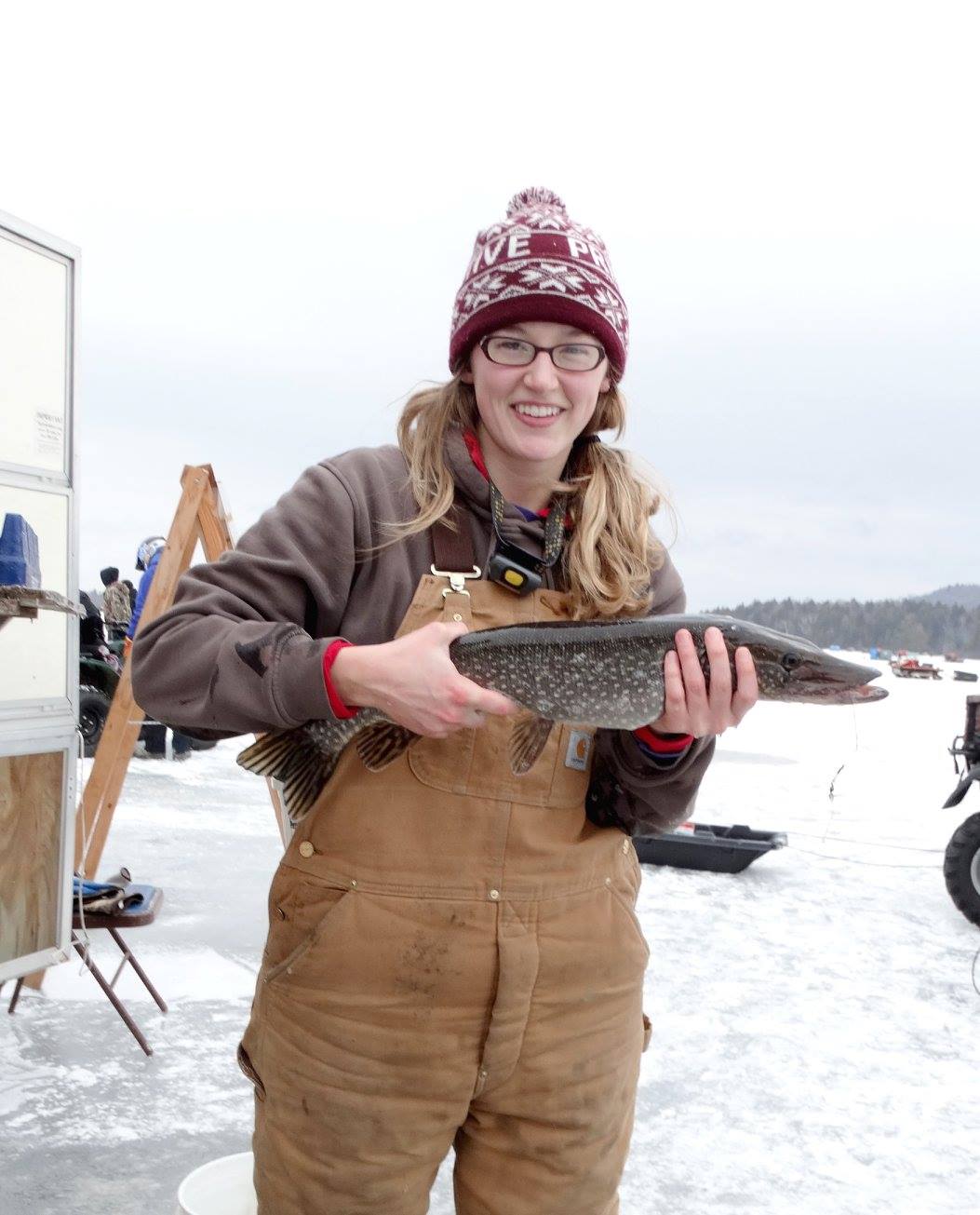 A woman holding a northern pike