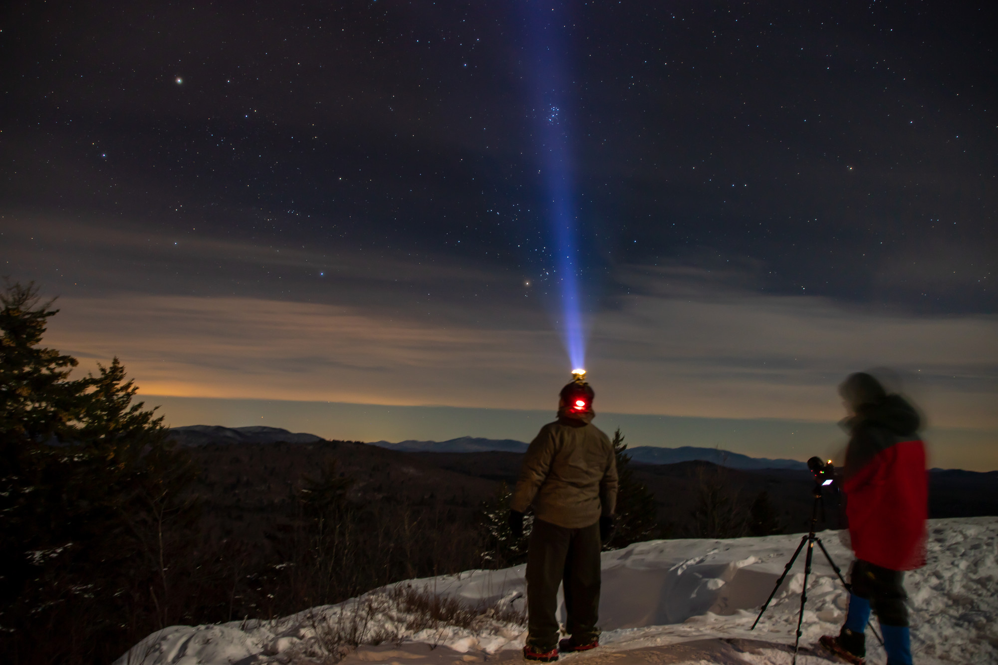 Someone stargazing on a winter summit