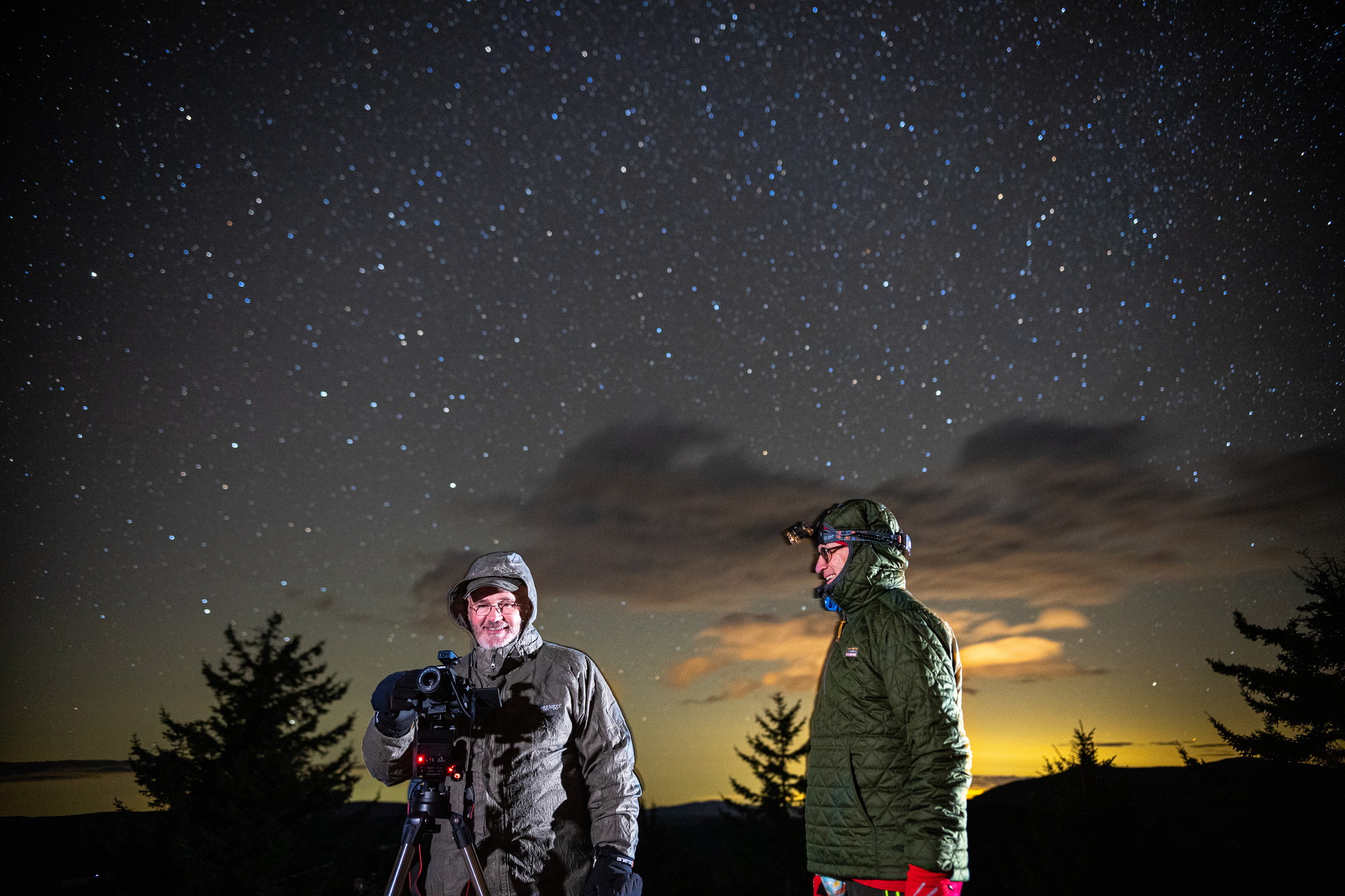 Two guys stargazing on a winter summit