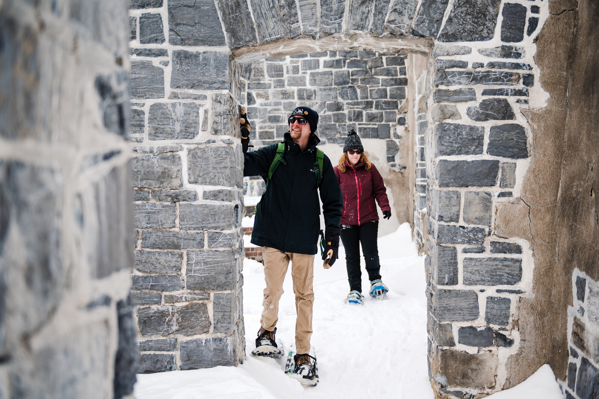 Two people snowshoeing at a fort ruin