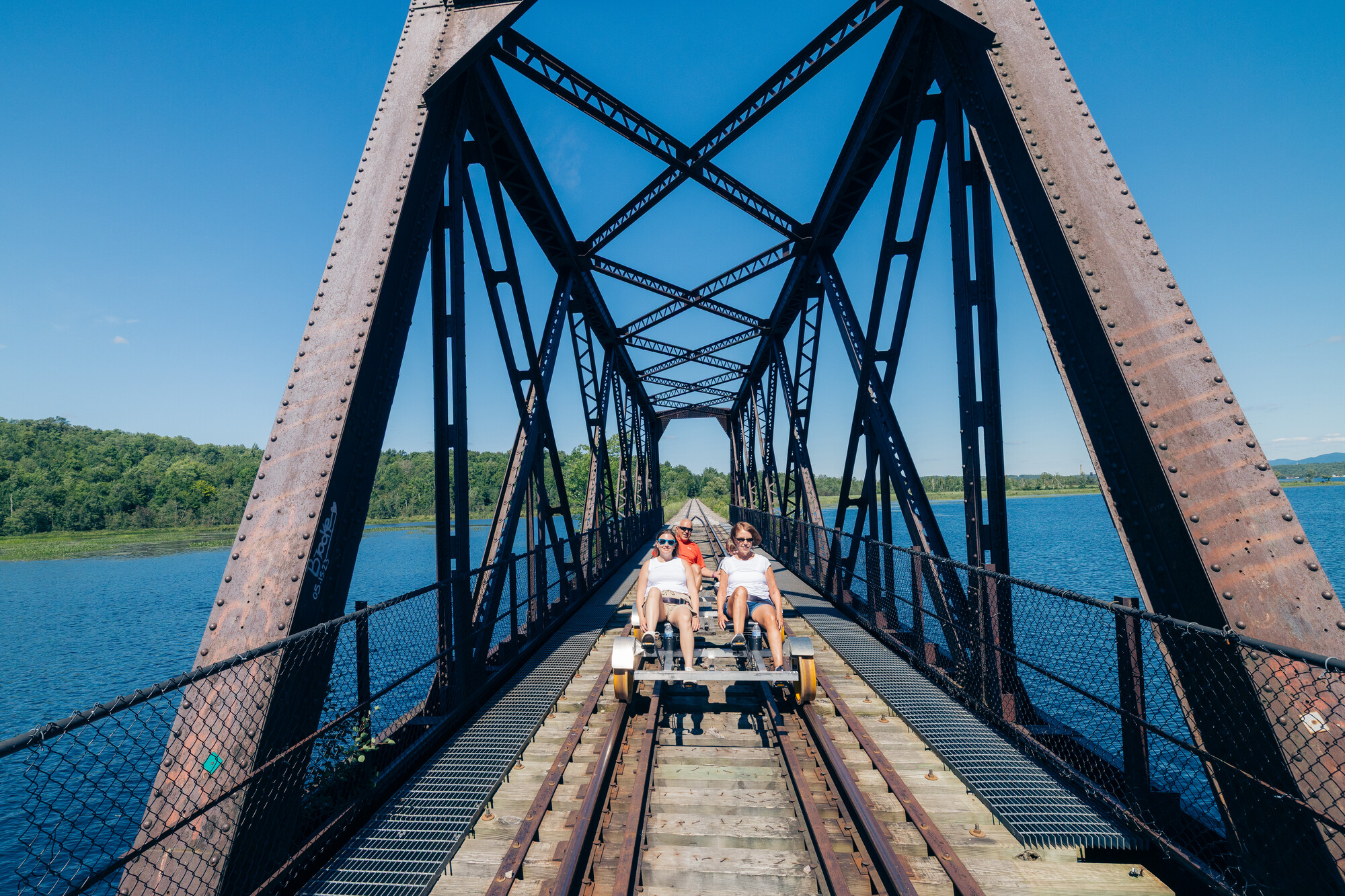 A family on a rail bike on a bridge