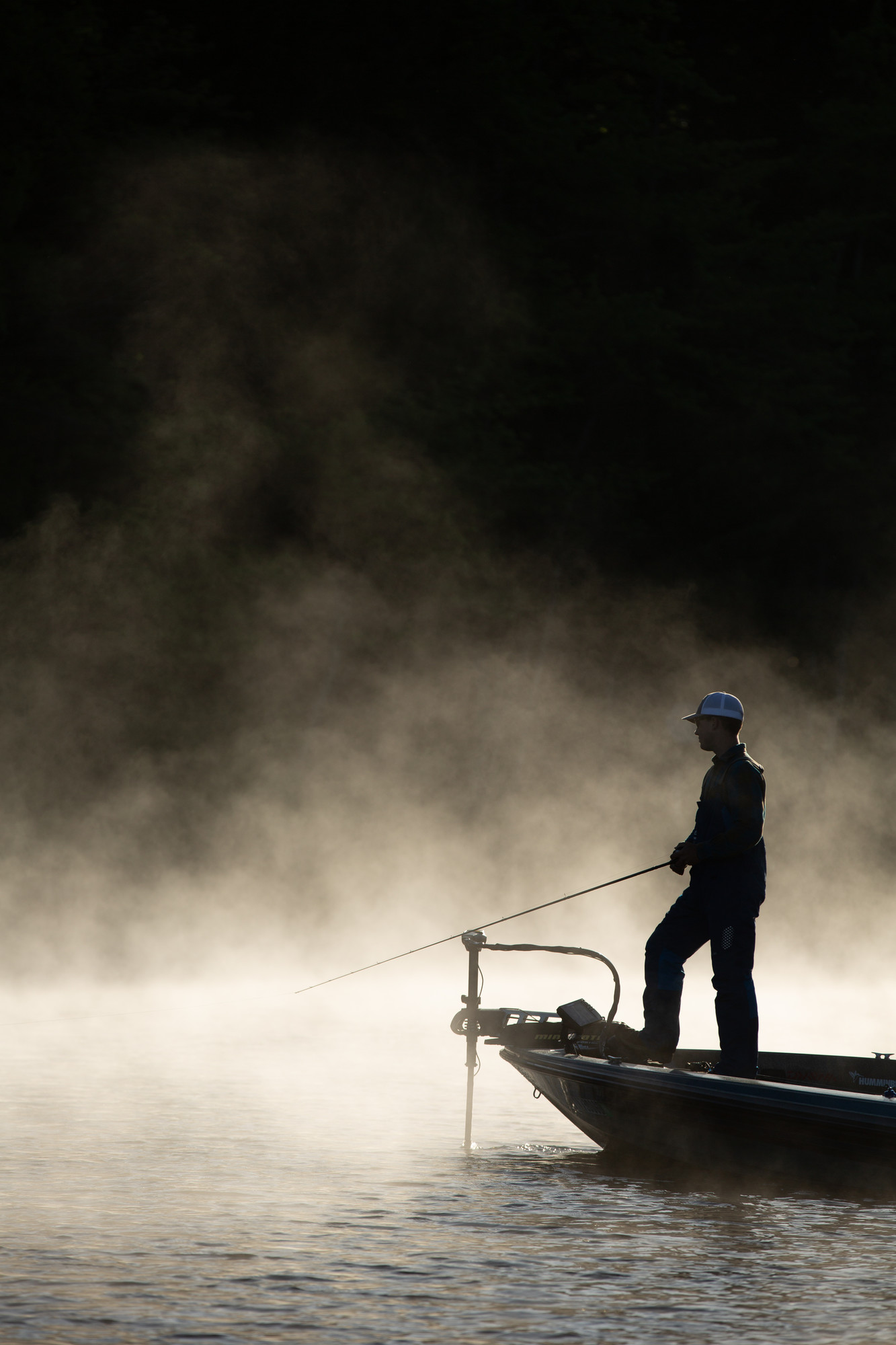 A man fishing in the early morning light