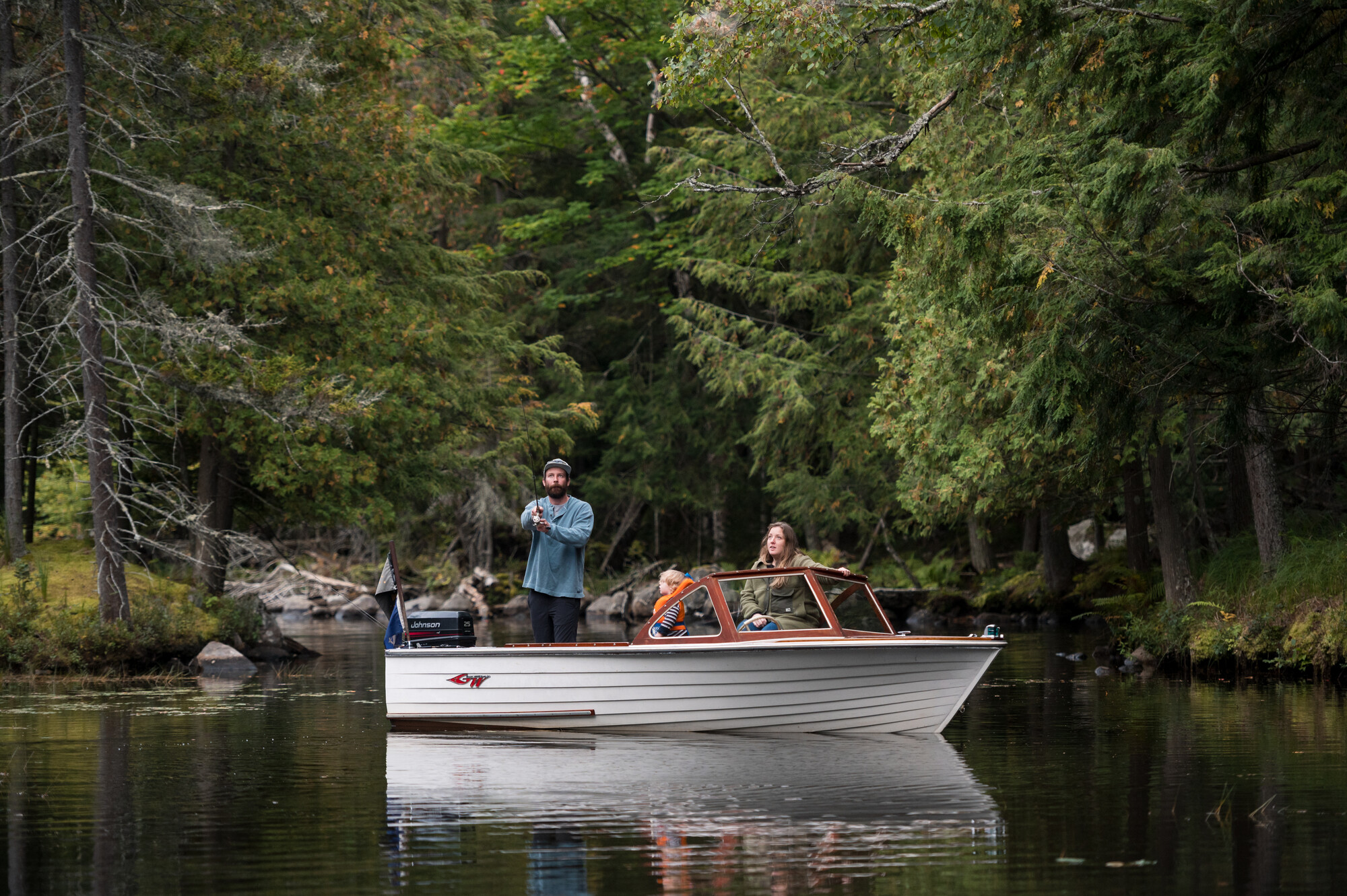 A couple people fishing from a small boat