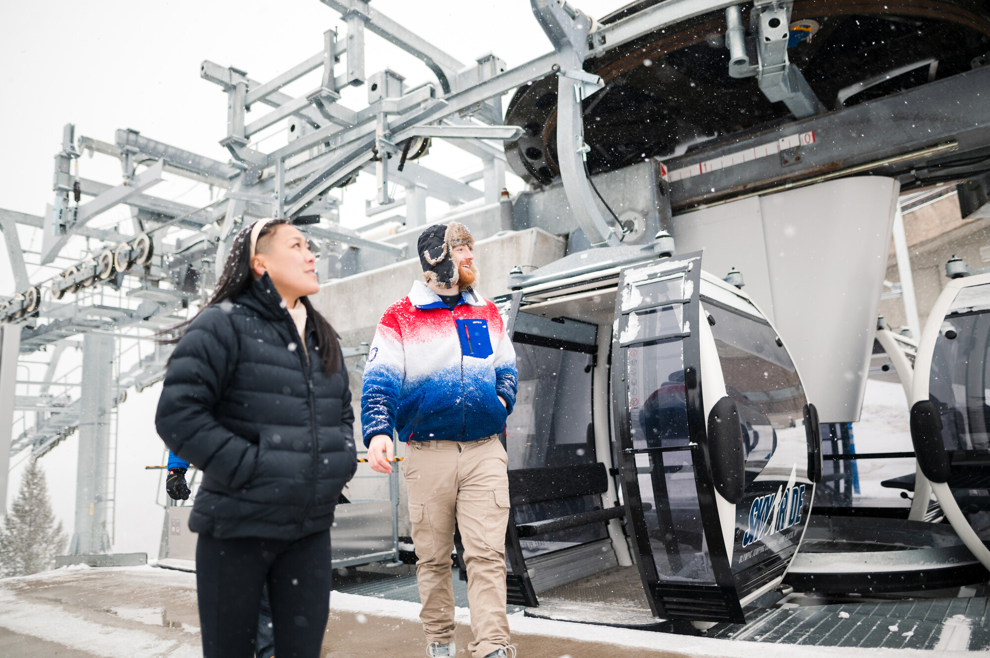 A couple coming off of a gondola in the winter