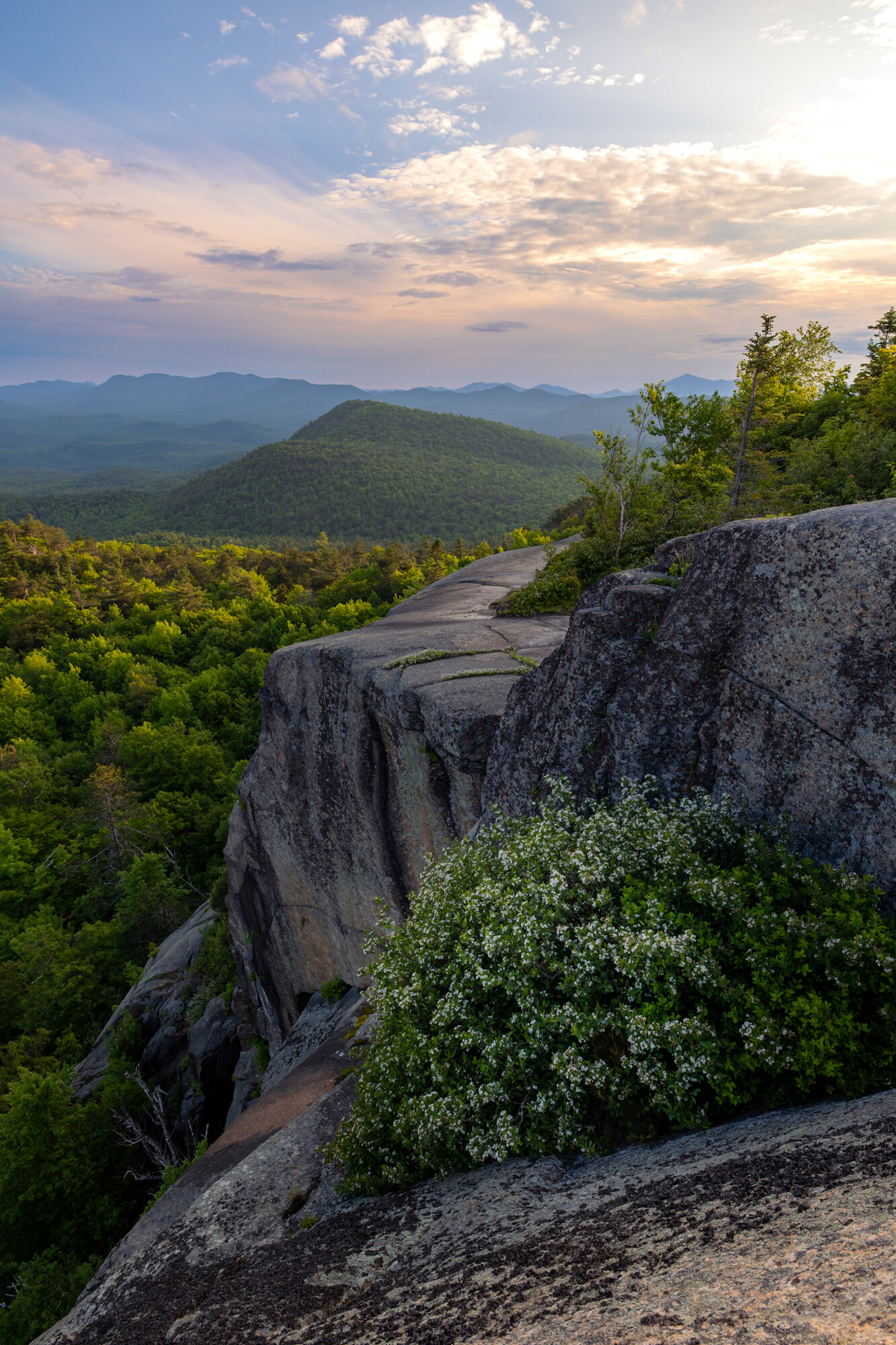 A view at sunrise of a cliff wall in a scenic mountain range.
