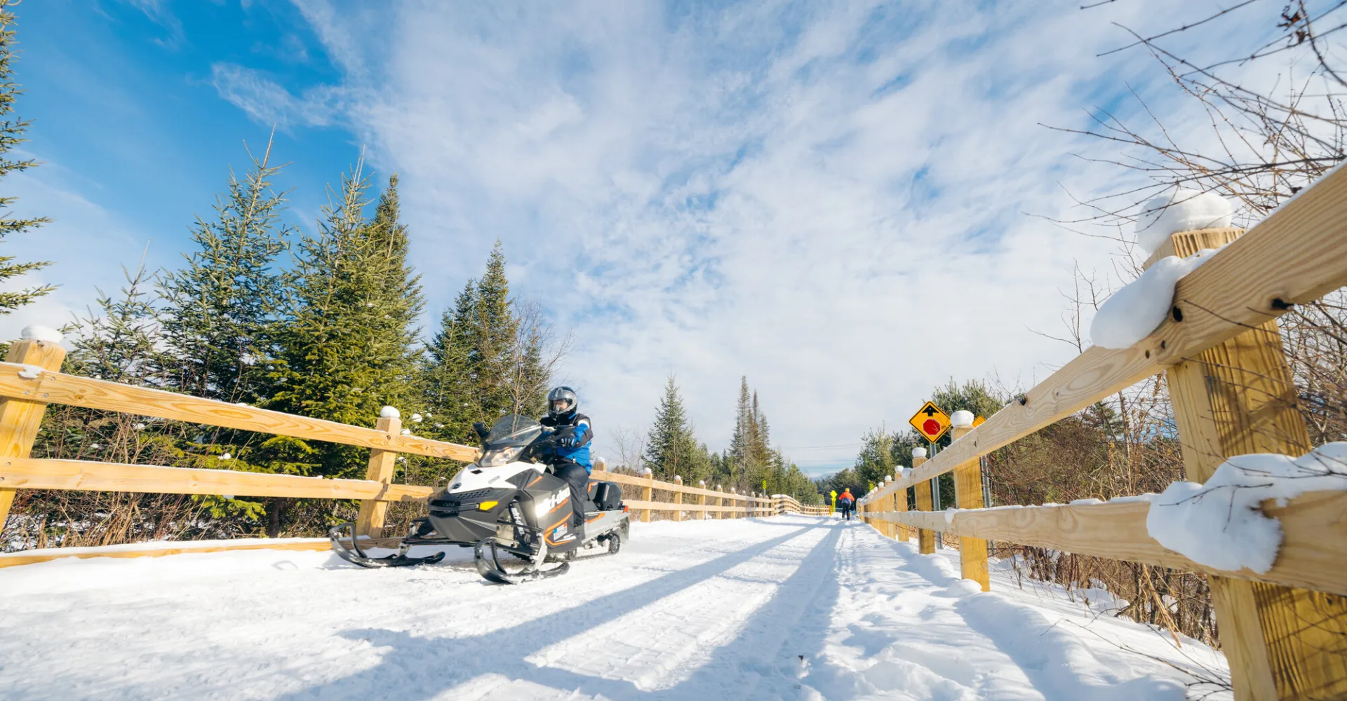 Snowmobile and a xc skier on the Adirondack Rail Trail