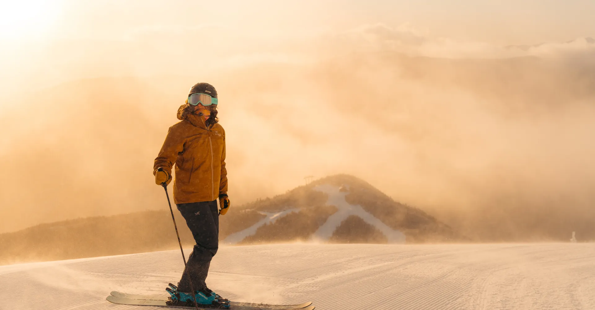 A skier standing on the summit in the morning light