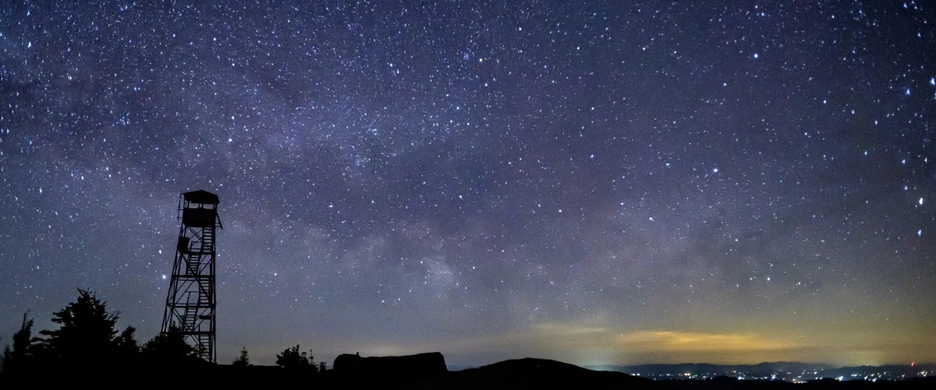 A night sky behind a fire tower