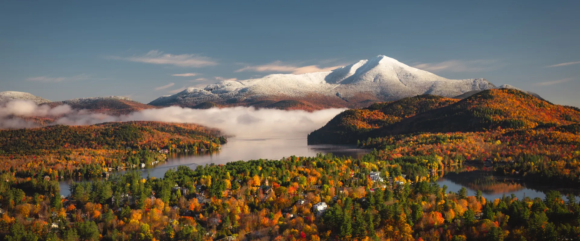 Snow in the mountains and fall foliage in town below