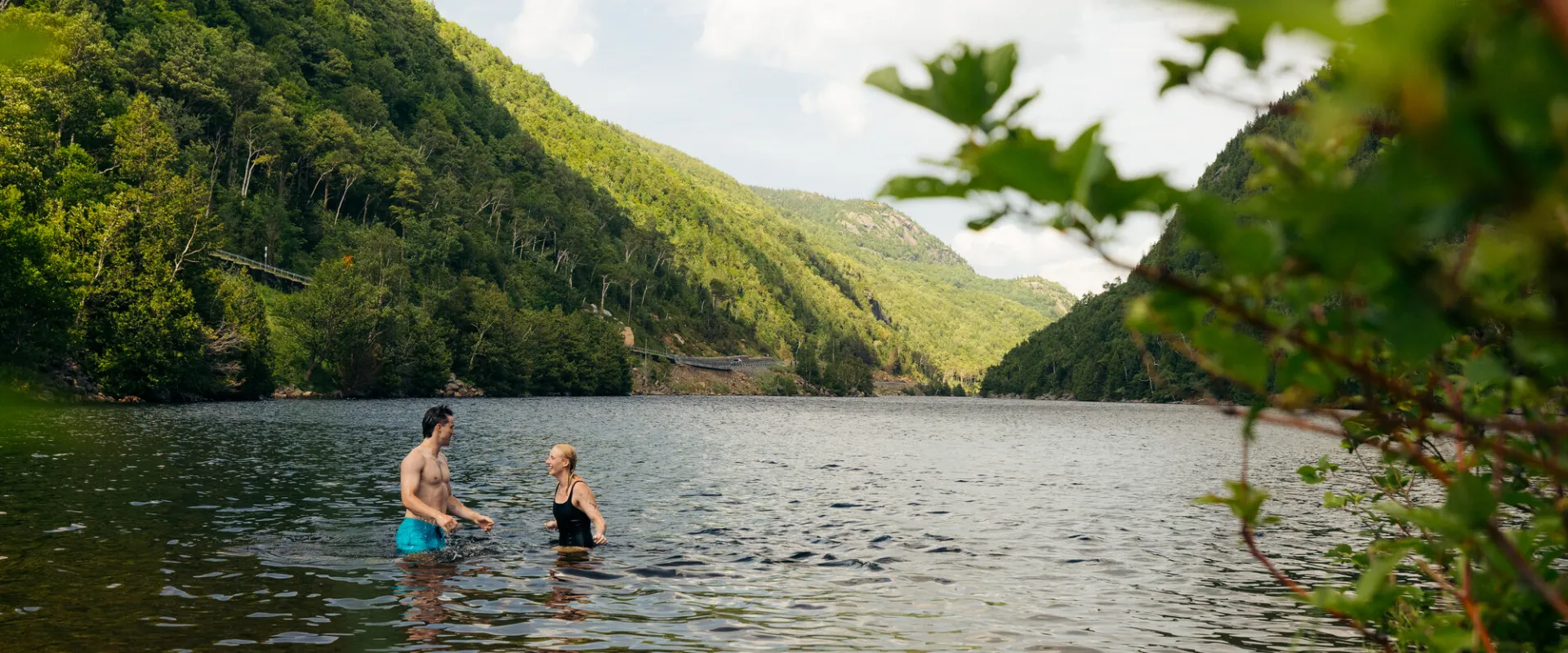 Two people swimming in a mountain lake