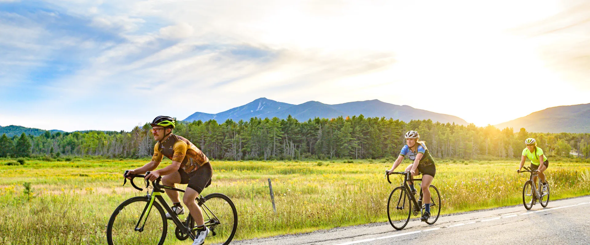 Cyclists on a road at sunset.
