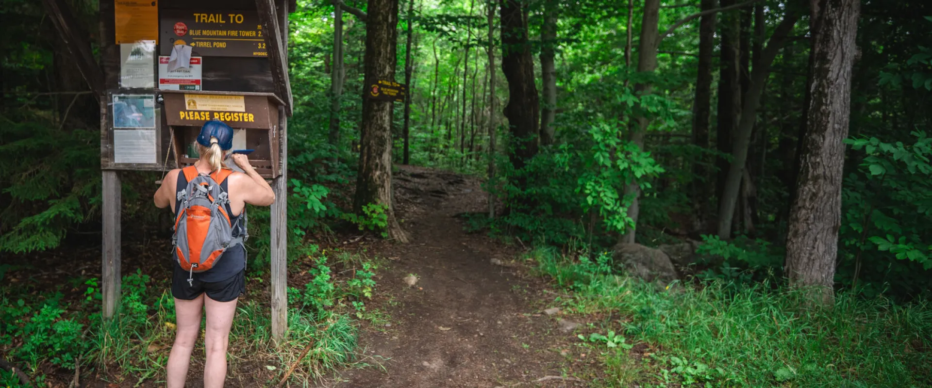 A woman signing in to a trail register