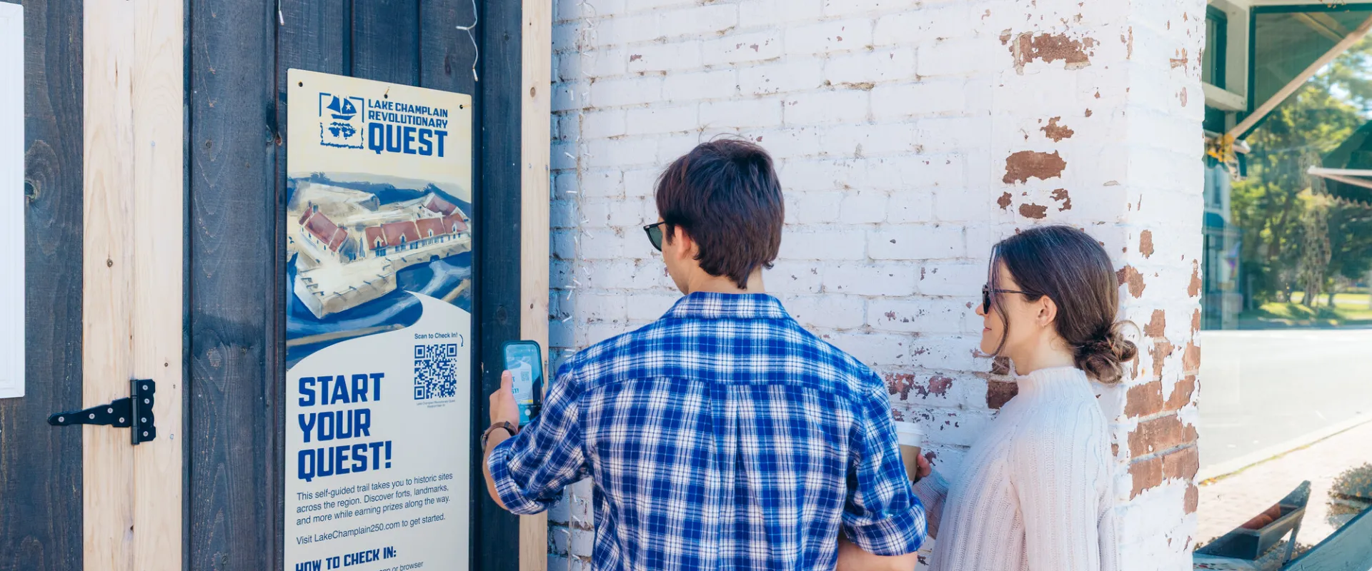 Two people scanning a Revolutionary Quest QR code