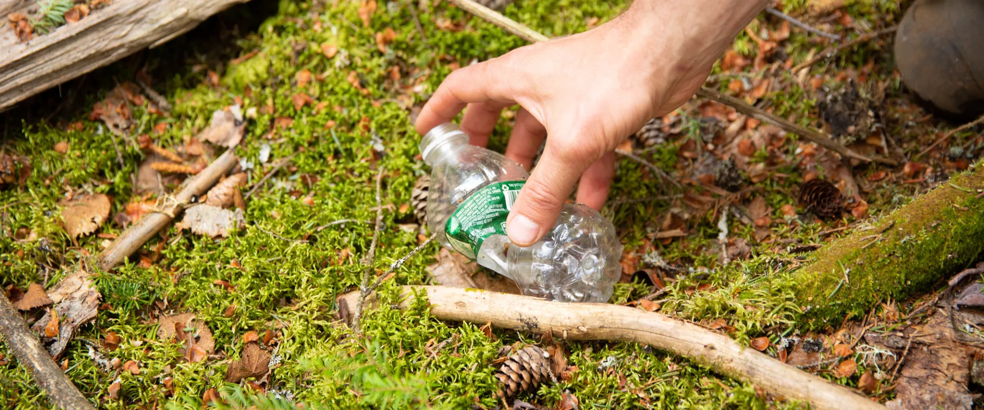 Someone picking up a used water bottle