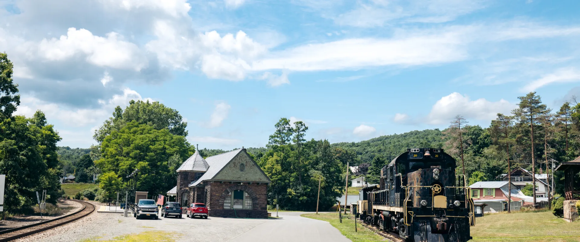 A train station with an old retired train sitting next to it. 
