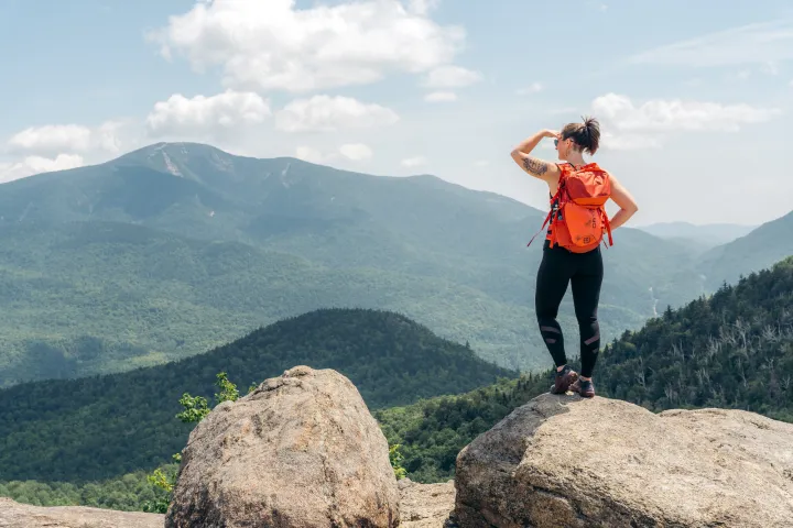 A hiker on a rocky summit enjoying the view