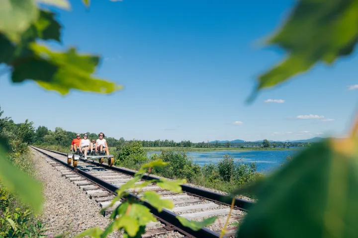 A family riding a rail bike by some water