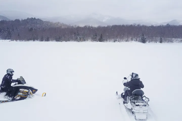 Snowmobilers on a frozen lake