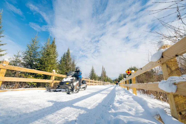 Snowmobiler going across a bridge