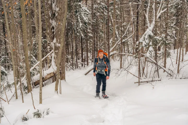 A snowshoer walking through the woods
