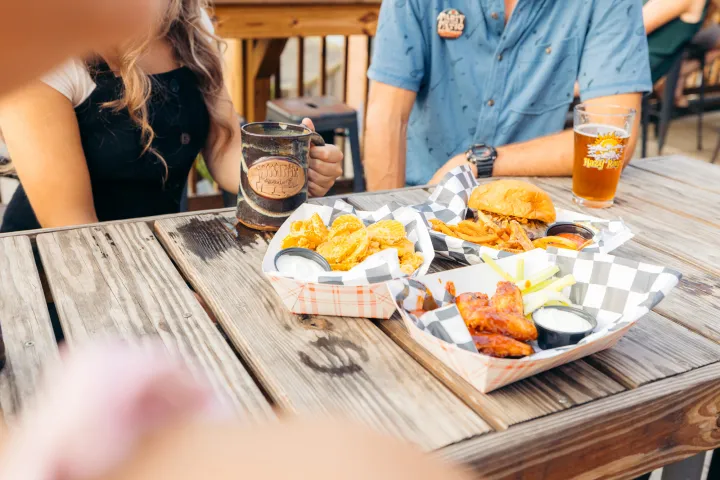 Food and drinks on a wooden table at a patio