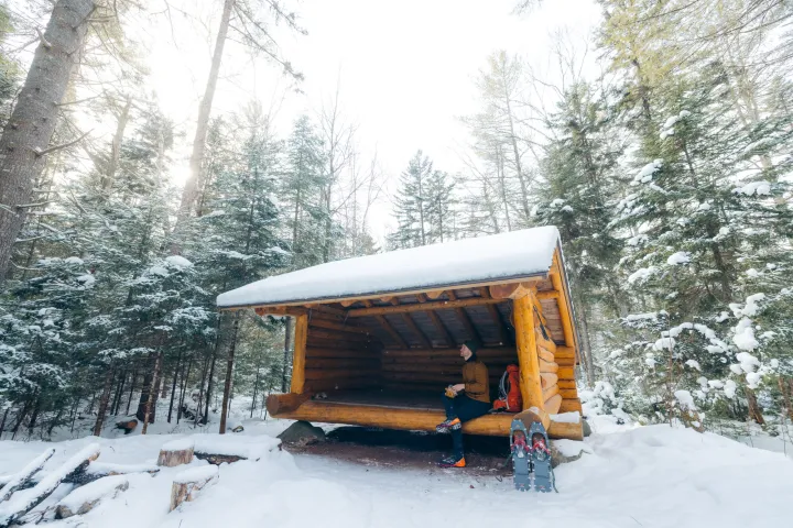 A snowshoer resting in a lean-to