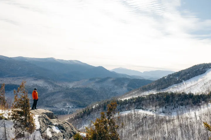 A snowshoer on a scenic rocky summit