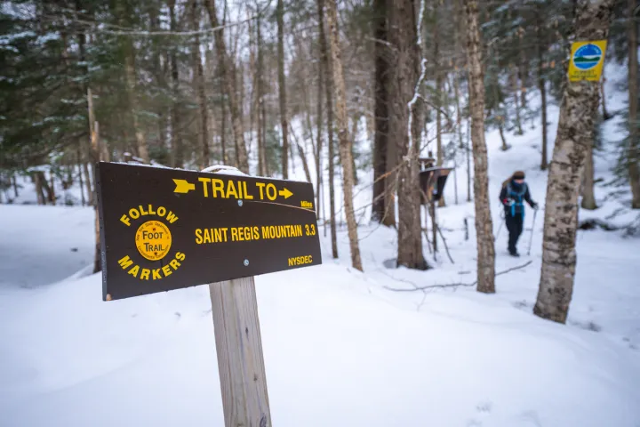 A wooden sign for Saint Regis Mountain in the winter