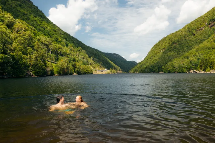 Two people swimming in a mountain lake