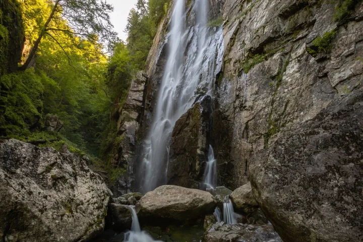 A massive waterfall in a mossy, rocky canyon