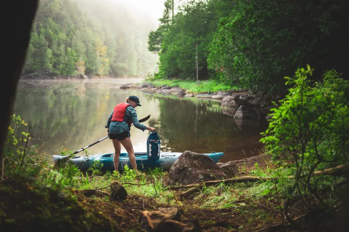 A paddler surrounded by green forest