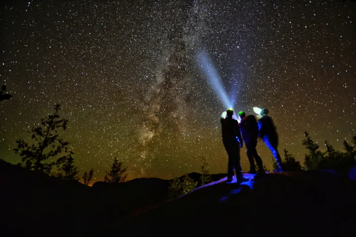 A group of people stargazing on a summit