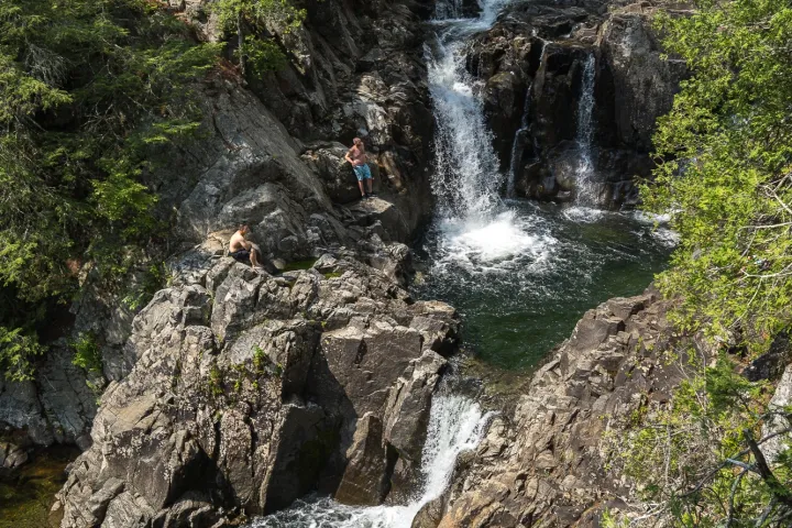 A two-tiered waterfall with some cliffjumpers