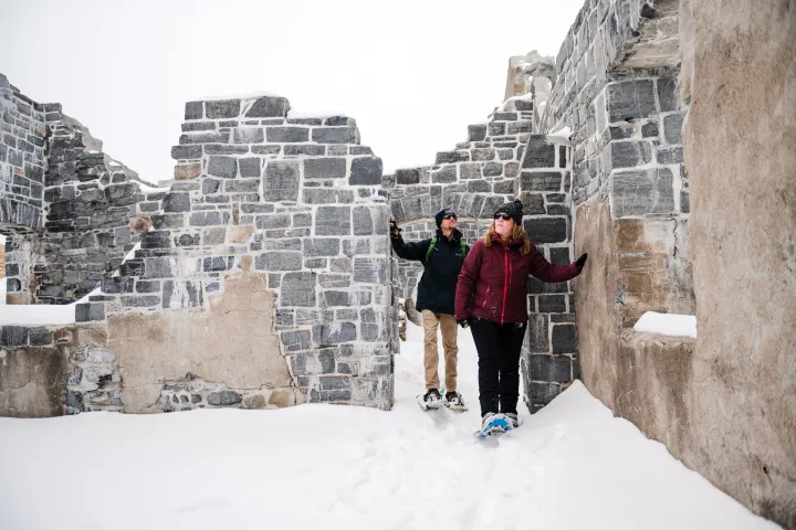 Snowshoers going through an old fort's remains