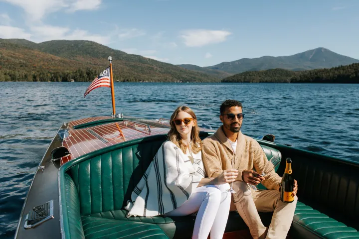 A couple on a fancy wood boat on Lake Placid