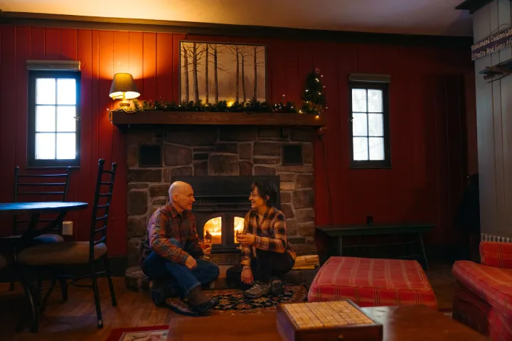 A couple sitting in front of a fire place
