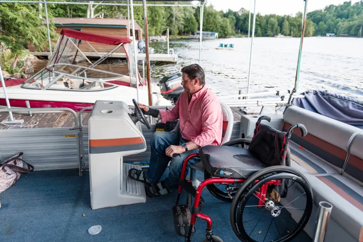 Someone with a wheelchair captaining a pontoon