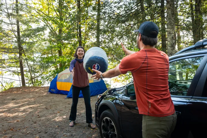 A couple getting ready to set up at a camp site