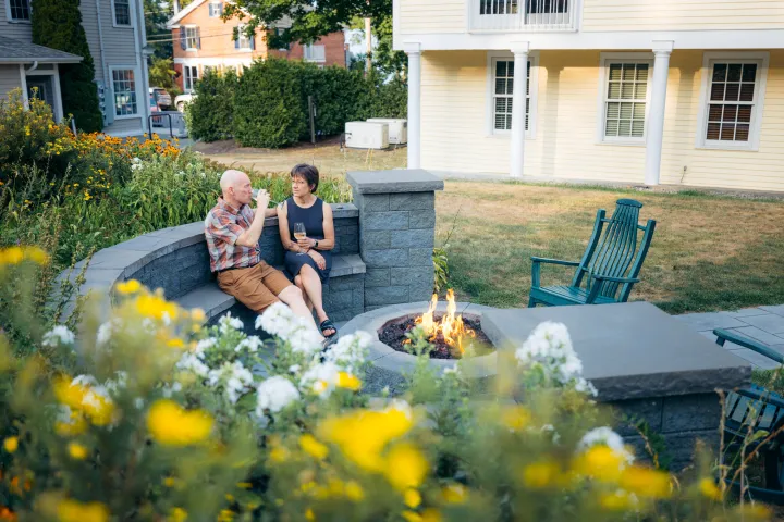 People sitting around a fire pit in the spring