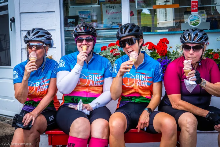 Cyclists eating ice cream cones.