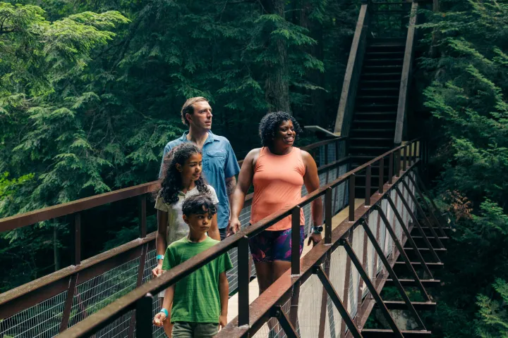 A family of four explores an outdoor trail. 