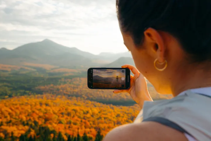 A person on a fall hike taking photos.